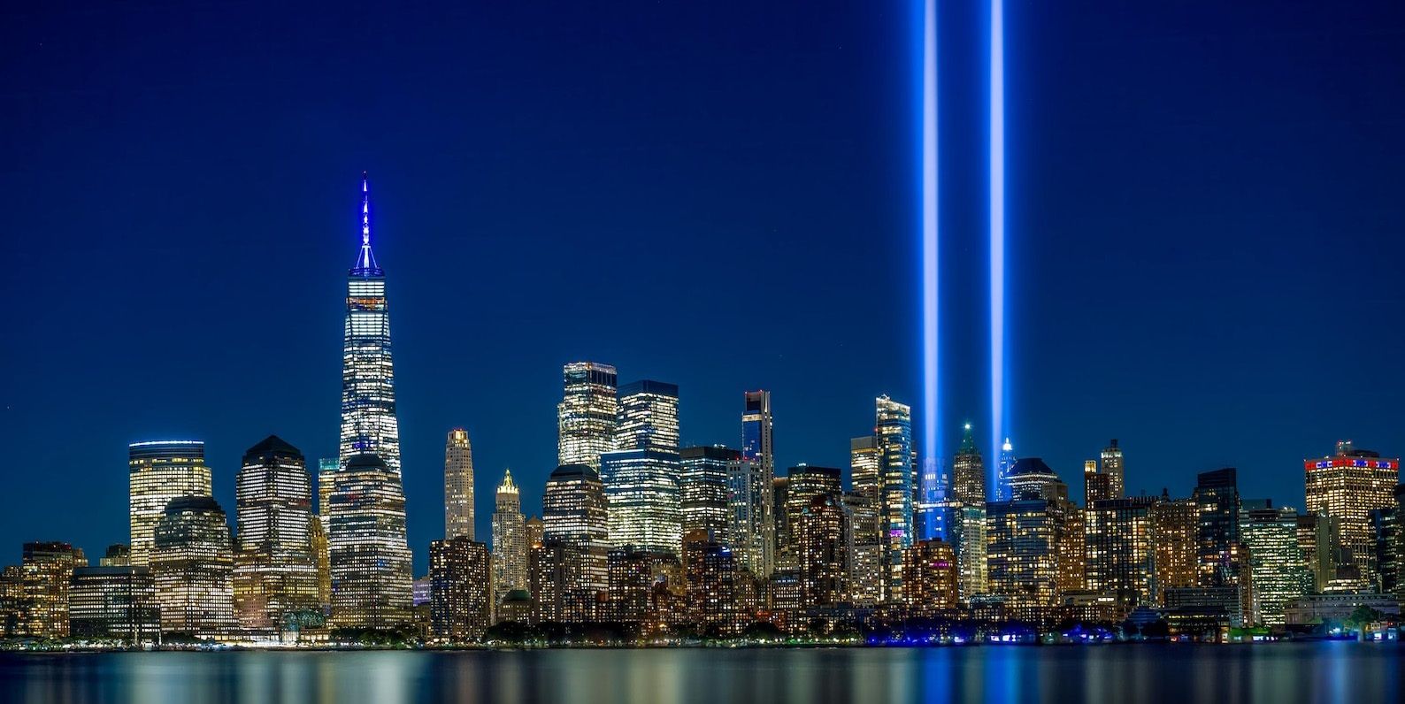 Tribute in Light, os dois feixes de luz sobre a baixa de Manhattan ao anoitecer