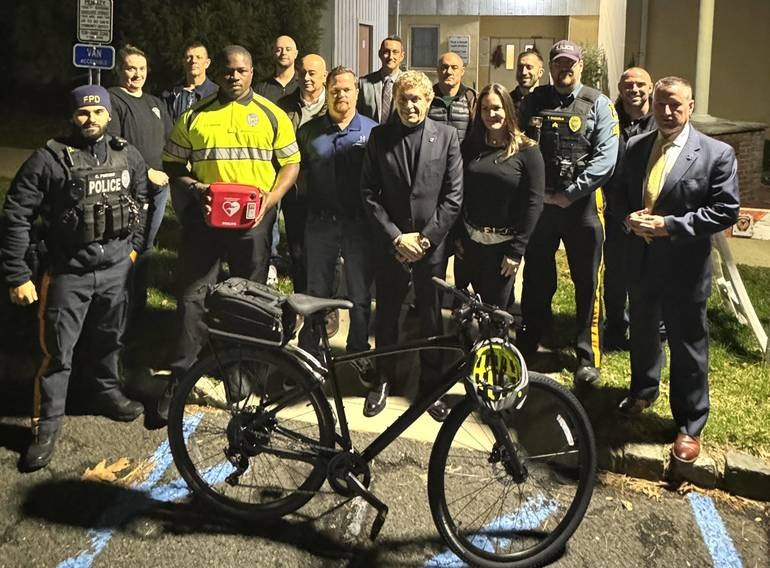 O Dr. César DePaço e sua esposa, Deanna Padovani-DePaço, com membros do departamento de polícia de Fanwood.